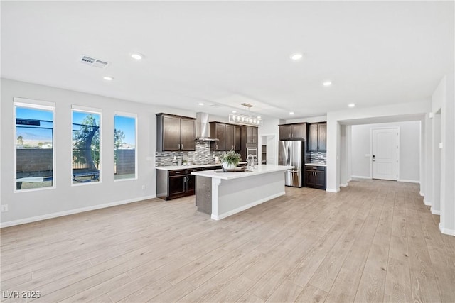 1512 Sagefield Way, Logandale, NV 89021 - kitchen with freestanding refrigerator, wall chimney range hood, backsplash, light countertops, and open floor plan