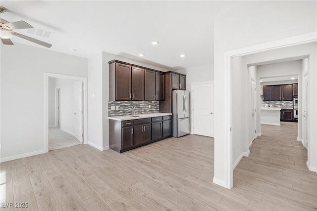 1512 Sagefield Way, Logandale, NV 89021 - kitchen with freestanding refrigerator, a ceiling fan, tasteful backsplash, dark brown cabinets, and light wood finished floors