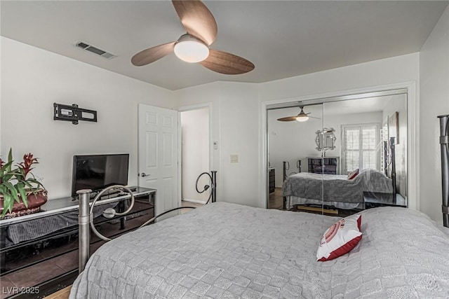 bedroom featuring a ceiling fan, wood finished floors, visible vents, and a closet