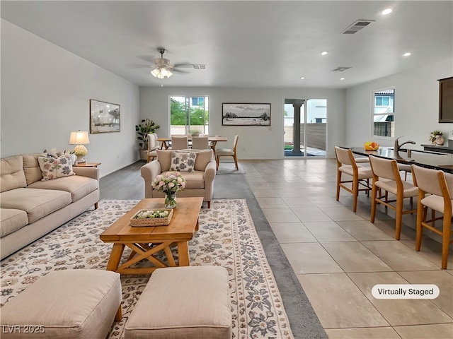 living area with light tile patterned floors, visible vents, recessed lighting, and ceiling fan