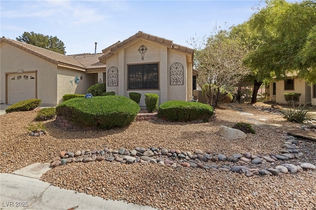 view of front of home with a garage, a tile roof, and stucco siding