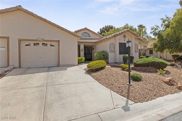 view of front facade featuring an attached garage, driveway, a tiled roof, and stucco siding