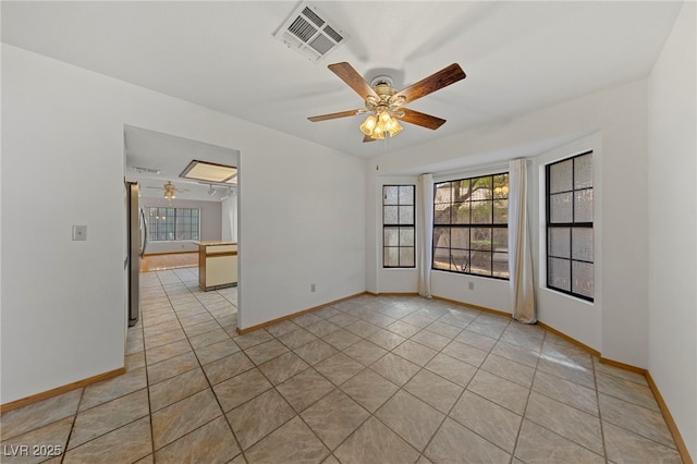 unfurnished room featuring baseboards, a ceiling fan, and visible vents