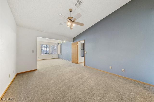 spare room featuring light carpet, visible vents, baseboards, lofted ceiling, and a ceiling fan