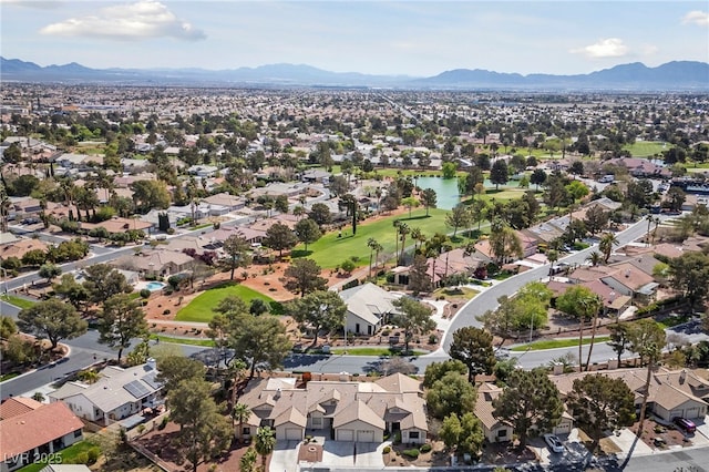 drone / aerial view featuring a water and mountain view and a residential view