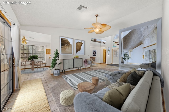 living room with lofted ceiling, baseboards, visible vents, and ceiling fan