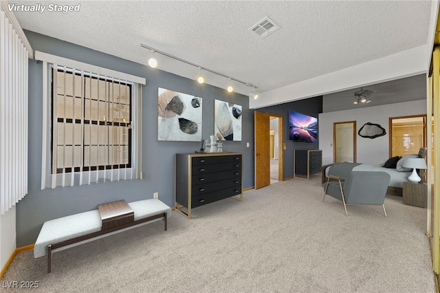 living room with visible vents, carpet floors, and a textured ceiling