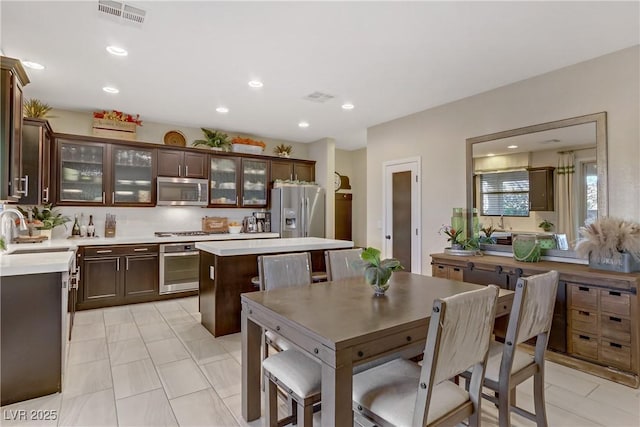 8992 Sparkling River Ct, Las Vegas, NV 89178 - kitchen with appliances with stainless steel finishes, dark brown cabinets, a sink, light countertops, and recessed lighting