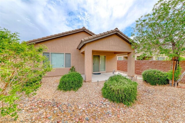 6116 Tokara Ave, Las Vegas, NV 89122 - rear view of house featuring fence, a patio, a tiled roof, and stucco siding