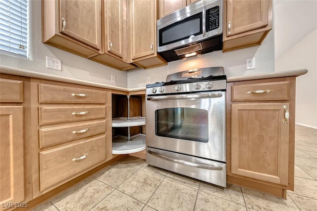 6116 Tokara Ave, Las Vegas, NV 89122 - kitchen featuring light tile patterned floors, light countertops, light brown cabinetry, and appliances with stainless steel finishes