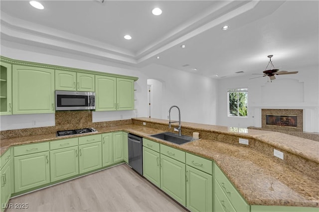 4722 Blue Mesa Way, Las Vegas, NV 89129 - kitchen with a sink, appliances with stainless steel finishes, a fireplace, ceiling fan, and light wood-style floors