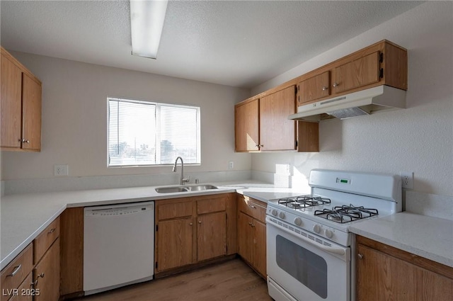 3953 Rebecca Raiter Ave Unit 202, Las Vegas, NV 89110 - kitchen with white appliances, light countertops, under cabinet range hood, a sink, and light wood finished floors