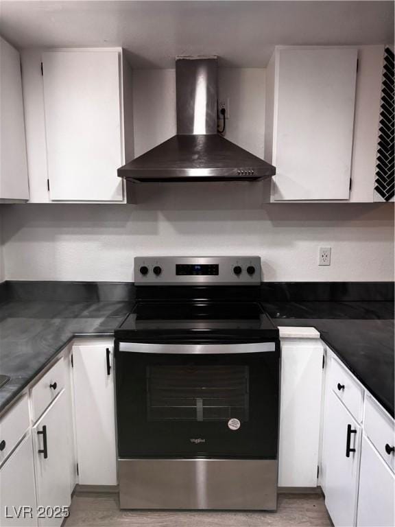 3275 Arville St Unit C, Las Vegas, NV 89102 - kitchen featuring wall chimney exhaust hood, stainless steel electric range oven, white cabinets, and dark countertops