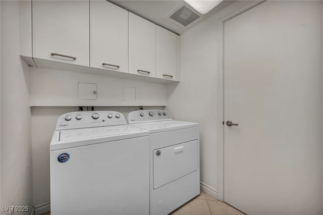 clothes washing area with washer and dryer, visible vents, light tile patterned floors, and cabinet space