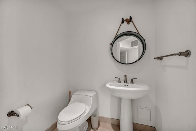 bathroom with toilet, baseboards, a sink, and tile patterned floors