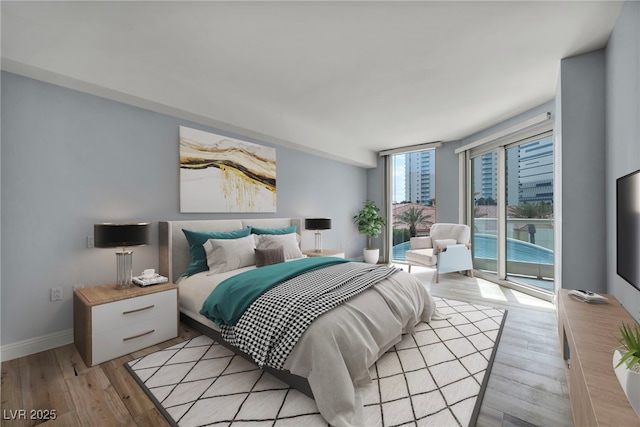 bedroom featuring access to outside, light wood-style flooring, and baseboards