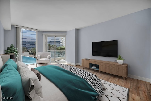 bedroom with baseboards, access to exterior, and wood finished floors