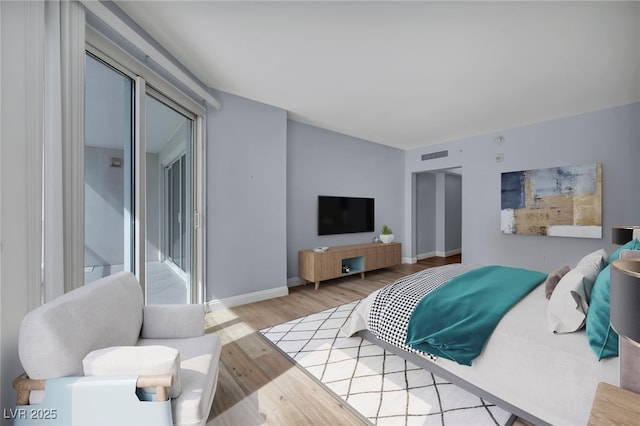 bedroom with baseboards, wood finished floors, and visible vents