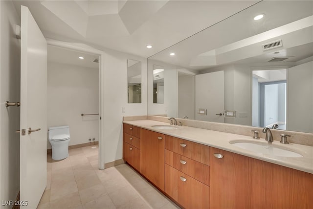 full bathroom with double vanity, toilet, visible vents, and a sink