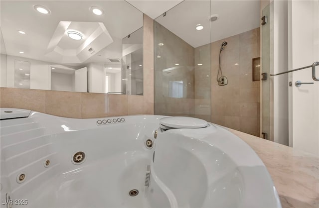bathroom featuring a jetted tub, tile walls, and a shower stall