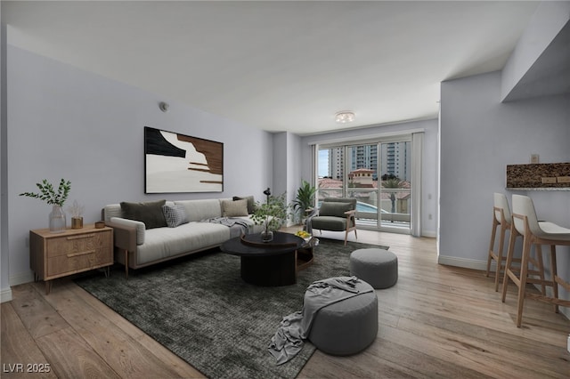 living area with baseboards and wood finished floors