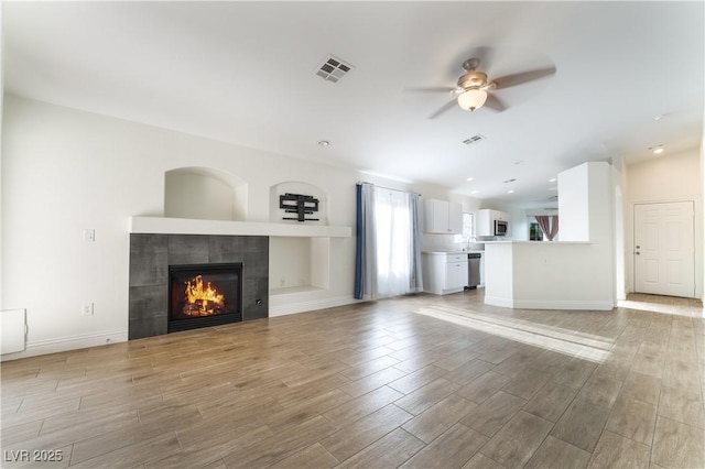 4360 Meadowlark Wing Way N, Las Vegas, NV 89084 - unfurnished living room featuring ceiling fan, light wood-style flooring, a fireplace, baseboards, and recessed lighting