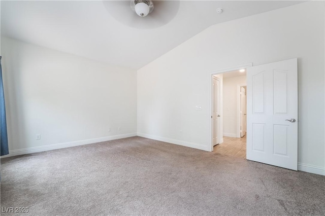 carpeted empty room featuring vaulted ceiling, a ceiling fan, and baseboards