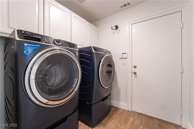4360 Meadowlark Wing Way N, Las Vegas, NV 89084 - laundry area with washing machine and dryer, light wood-style flooring, cabinet space, and baseboards