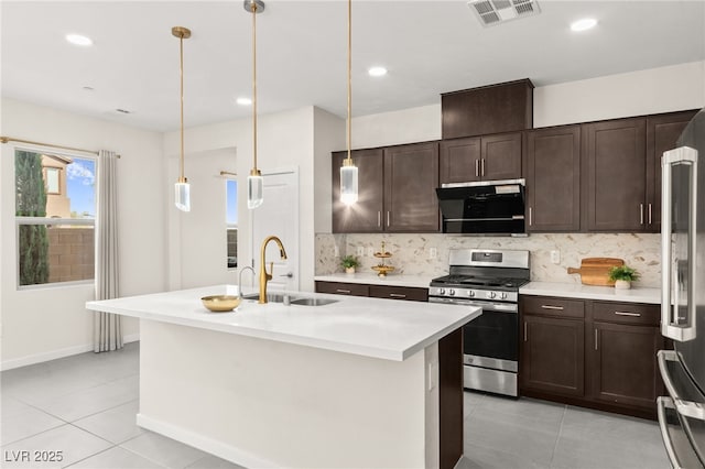 kitchen featuring dark brown cabinets, a sink, light tile patterned flooring, appliances with stainless steel finishes, and visible vents