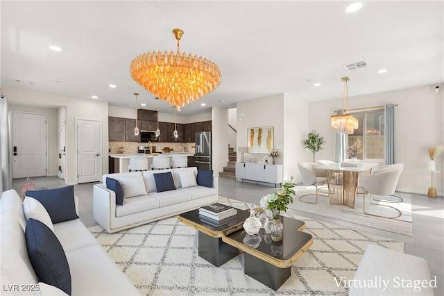 living room with baseboards, visible vents, recessed lighting, a notable chandelier, and stairs