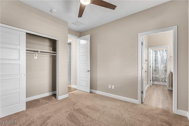 unfurnished bedroom with light colored carpet, a closet, baseboards, and ceiling fan