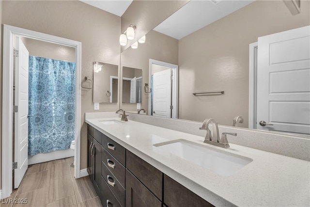bathroom featuring toilet and double vanity