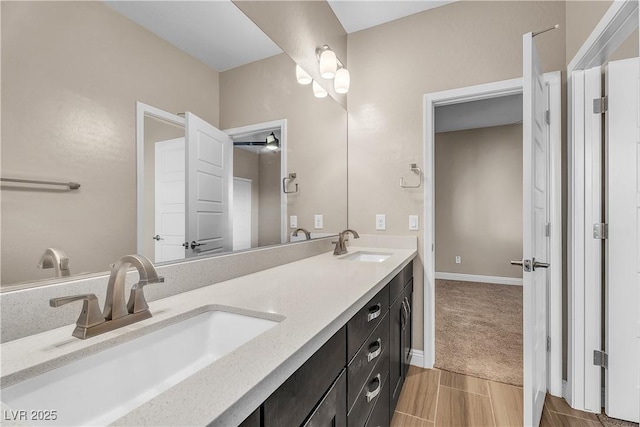 bathroom with double vanity and baseboards