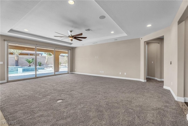 carpeted empty room with a raised ceiling, a ceiling fan, baseboards, and recessed lighting