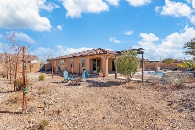 back of property featuring an outdoor fire pit, fence, metal roof, stucco siding, and a patio area