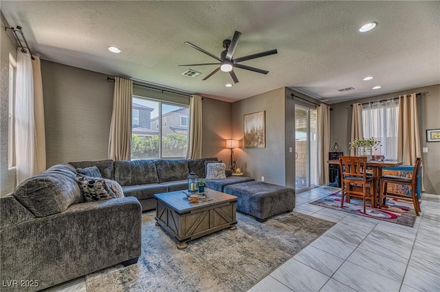 living area featuring ceiling fan, a textured ceiling, visible vents, and recessed lighting