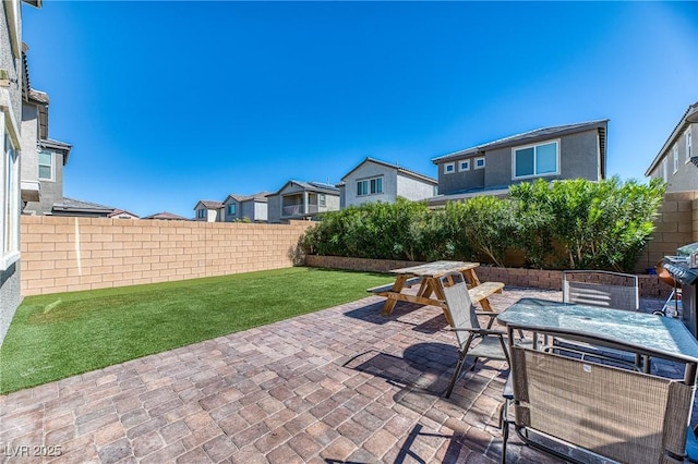 view of patio featuring a fenced backyard, a residential view, and outdoor dining space