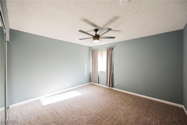 carpeted spare room with baseboards, a textured ceiling, and ceiling fan
