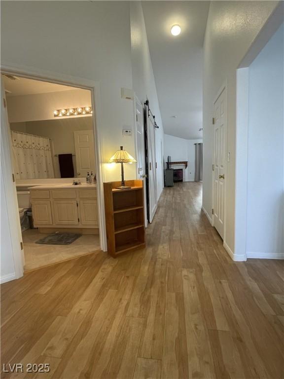 corridor with a barn door and light wood-type flooring