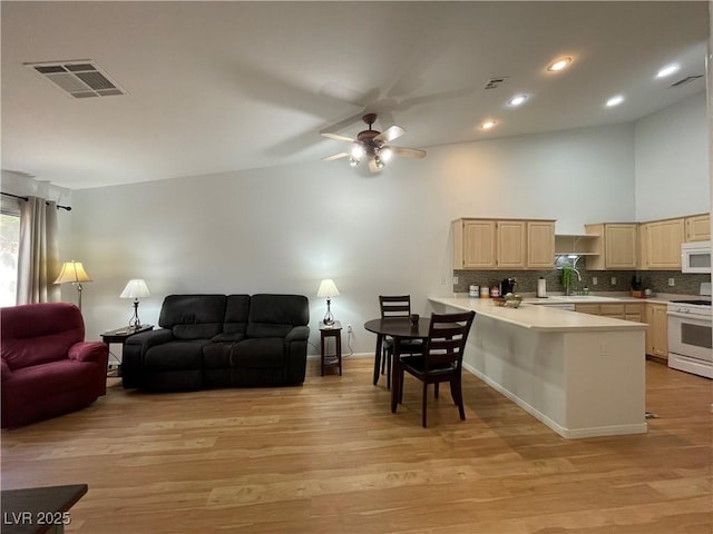 living room featuring ceiling fan, baseboards, light wood-style floors, and visible vents