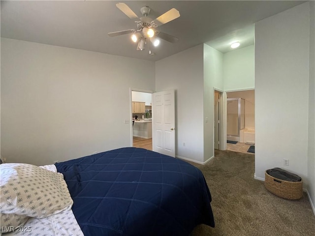 carpeted bedroom with ensuite bath, baseboards, and ceiling fan