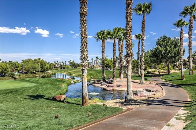 view of community with a lawn and a water view