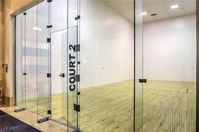 full bath featuring a stall shower and a sport court
