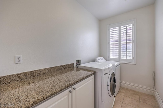 clothes washing area featuring baseboards, cabinet space, washing machine and clothes dryer, and light tile patterned flooring