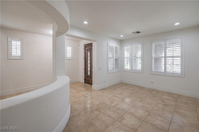 foyer with light tile patterned floors, visible vents, plenty of natural light, and recessed lighting