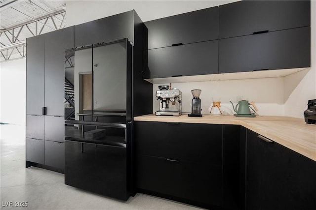 kitchen featuring dark cabinetry, light countertops, concrete floors, and modern cabinets