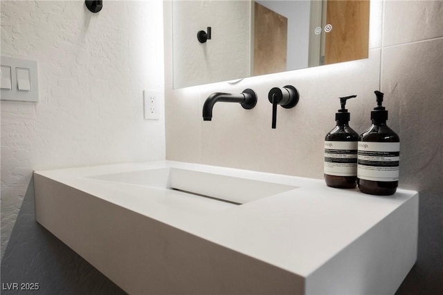 room details featuring a sink and a textured wall