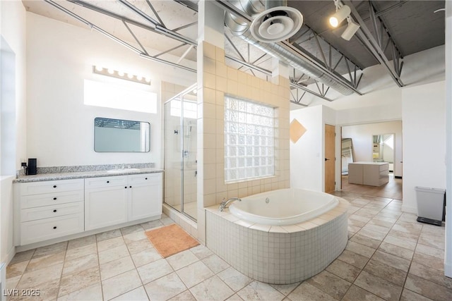 full bath with vanity, a stall shower, and a garden tub