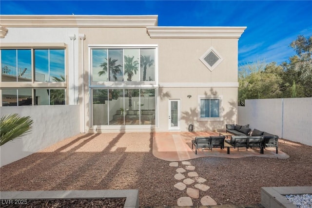 rear view of house featuring a patio, an outdoor living space, fence, and stucco siding