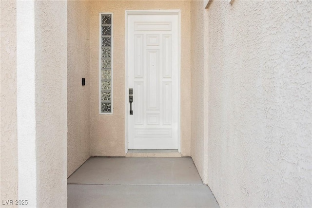property entrance featuring stucco siding